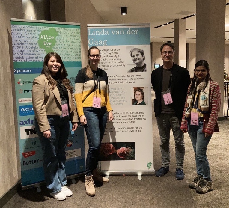 A photo of my colleagues and I with an exhibition banner of another colleague.