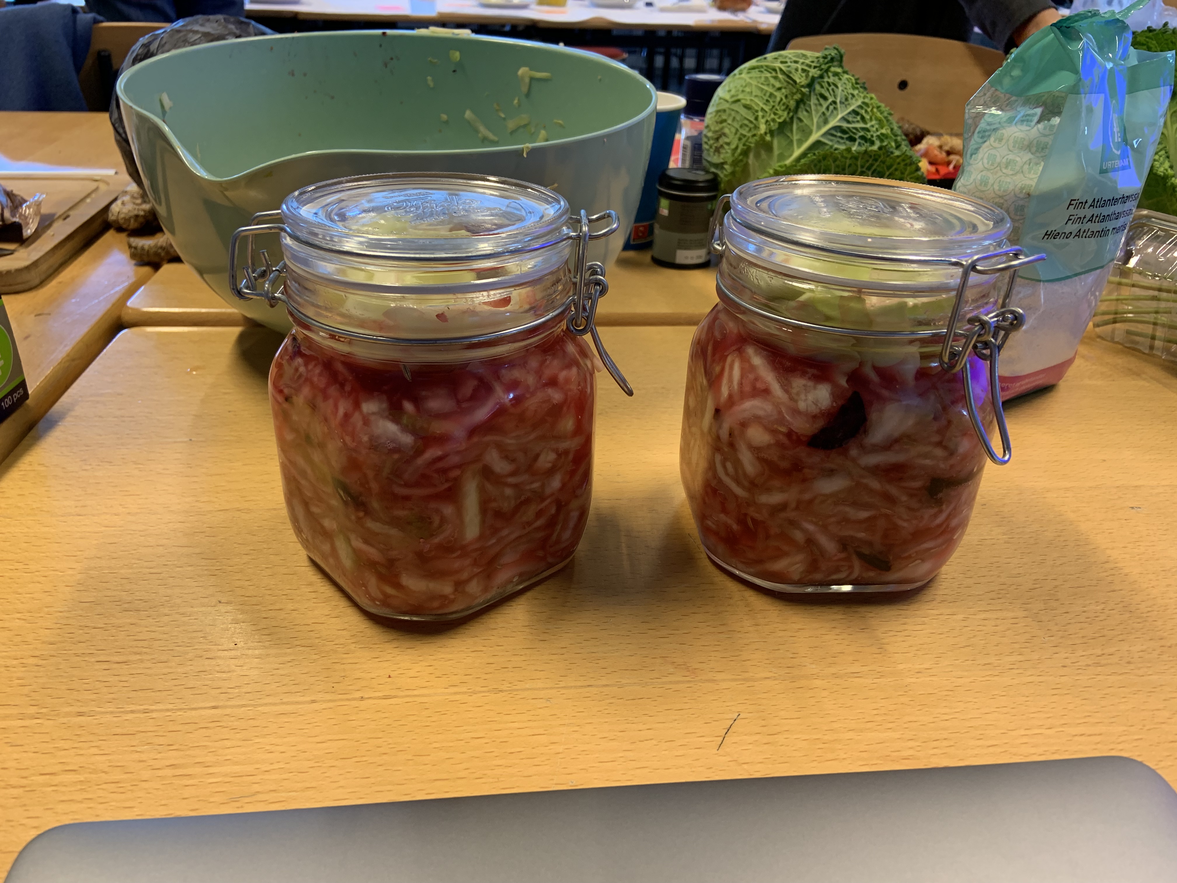 Shredded cabbage and beetroot fermenting products that have been put into two medium-sized jars for fermentation.