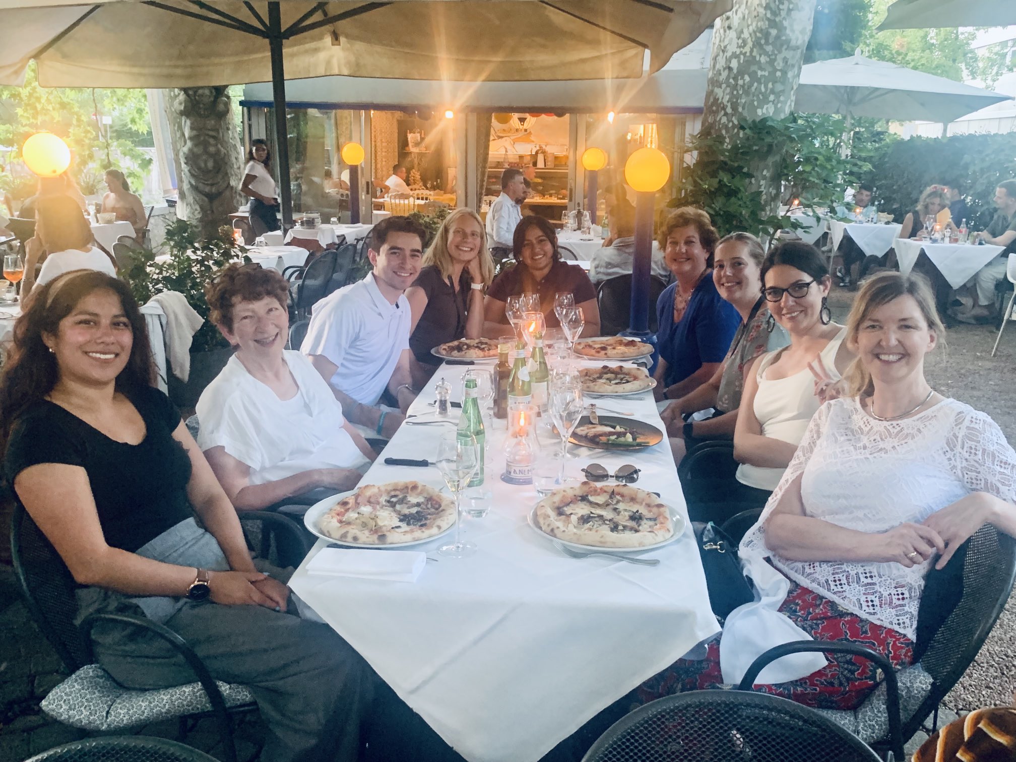 A table at the restaurant with 9 ICER attendees sitting around it, looking at the camera.