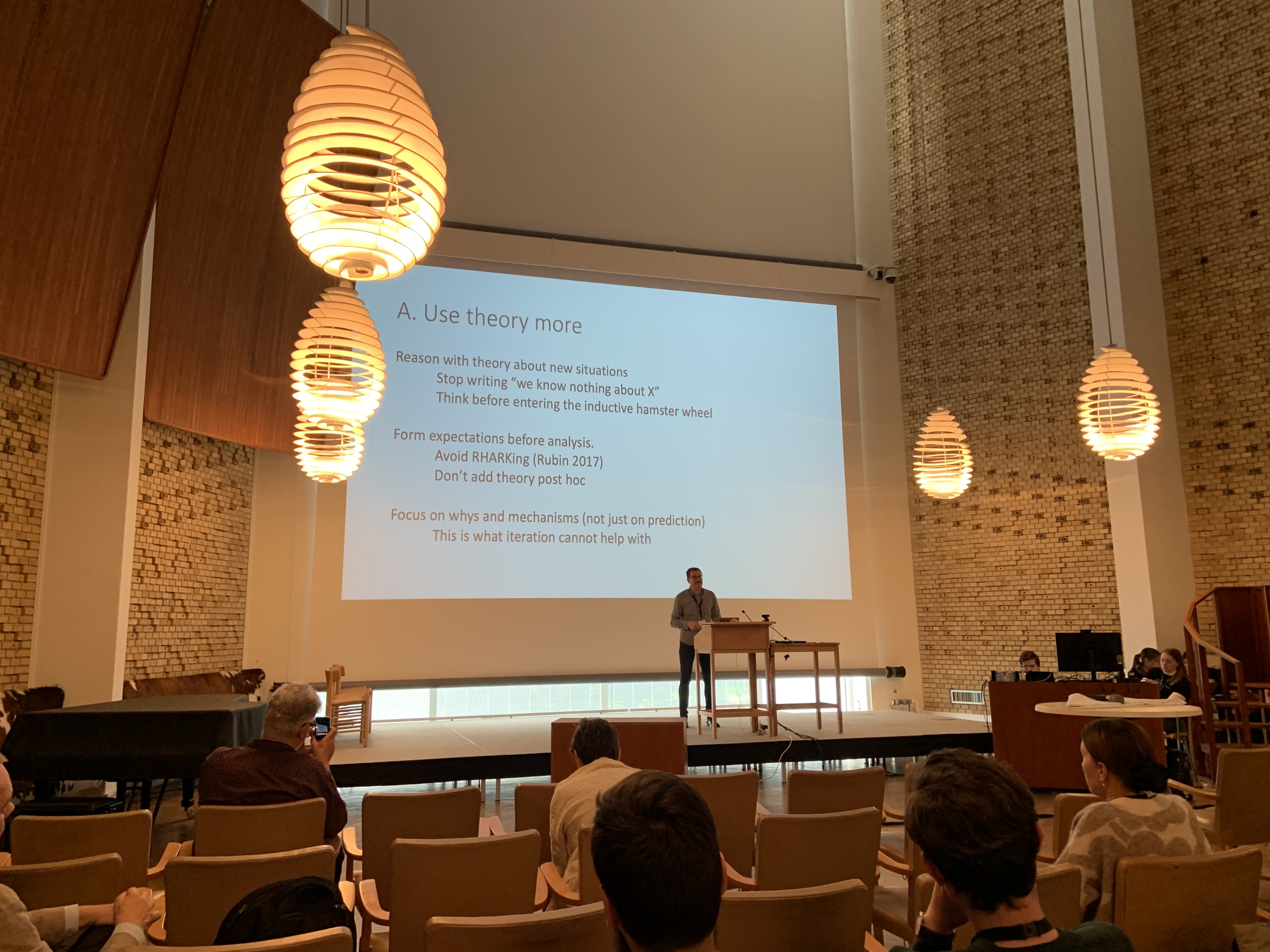 Kasper on stage in the Aarhus University aula, presenting his keynote Implications for Theory.