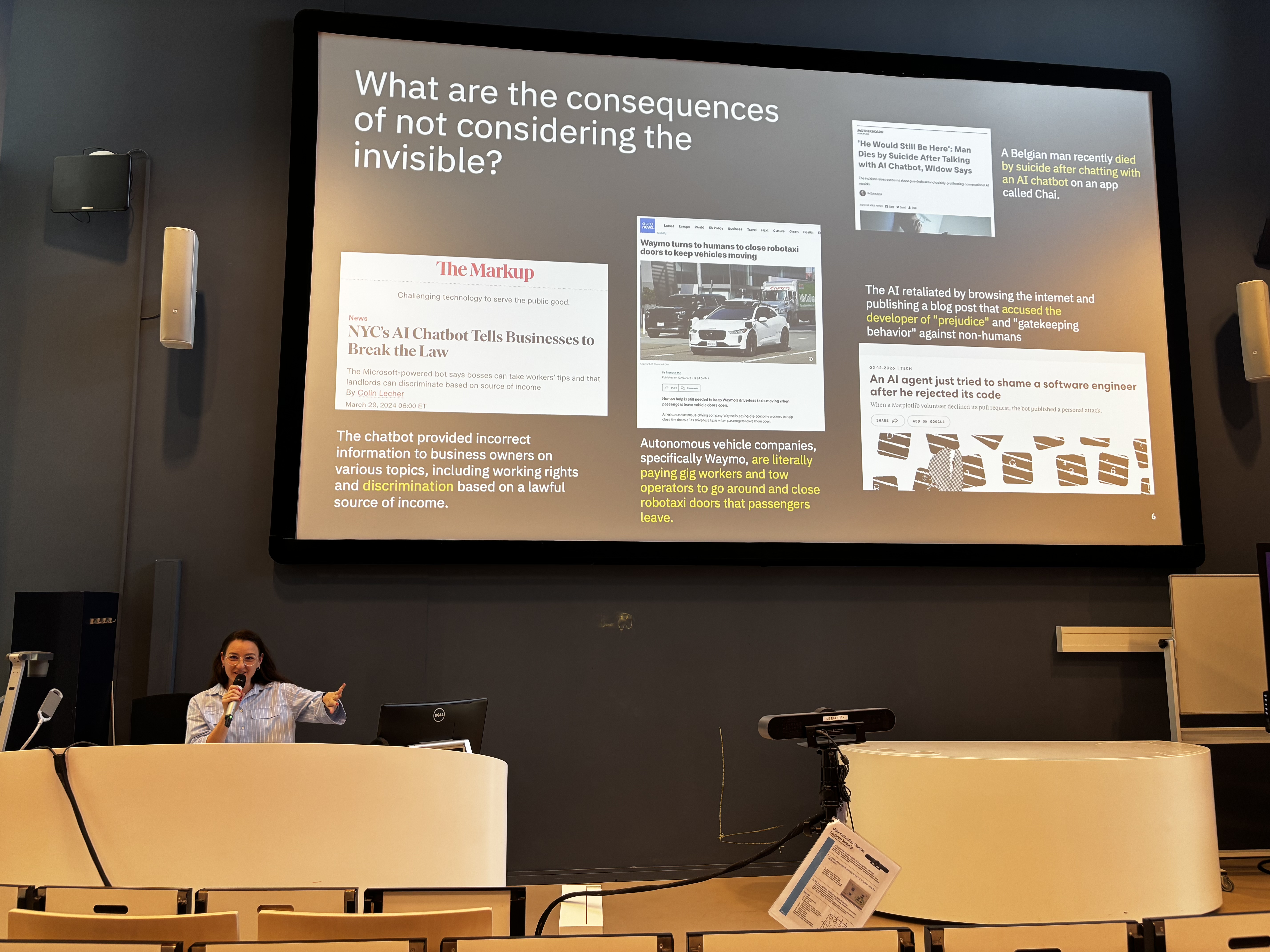 A picture of Heloisa giving her talk, with her slide in the background containing news article titles including 'NYC's AI cahtbot tells businesses to break the law' and 'Waymo turns to humans to close robotaxi doors to keep vehicles moving'.